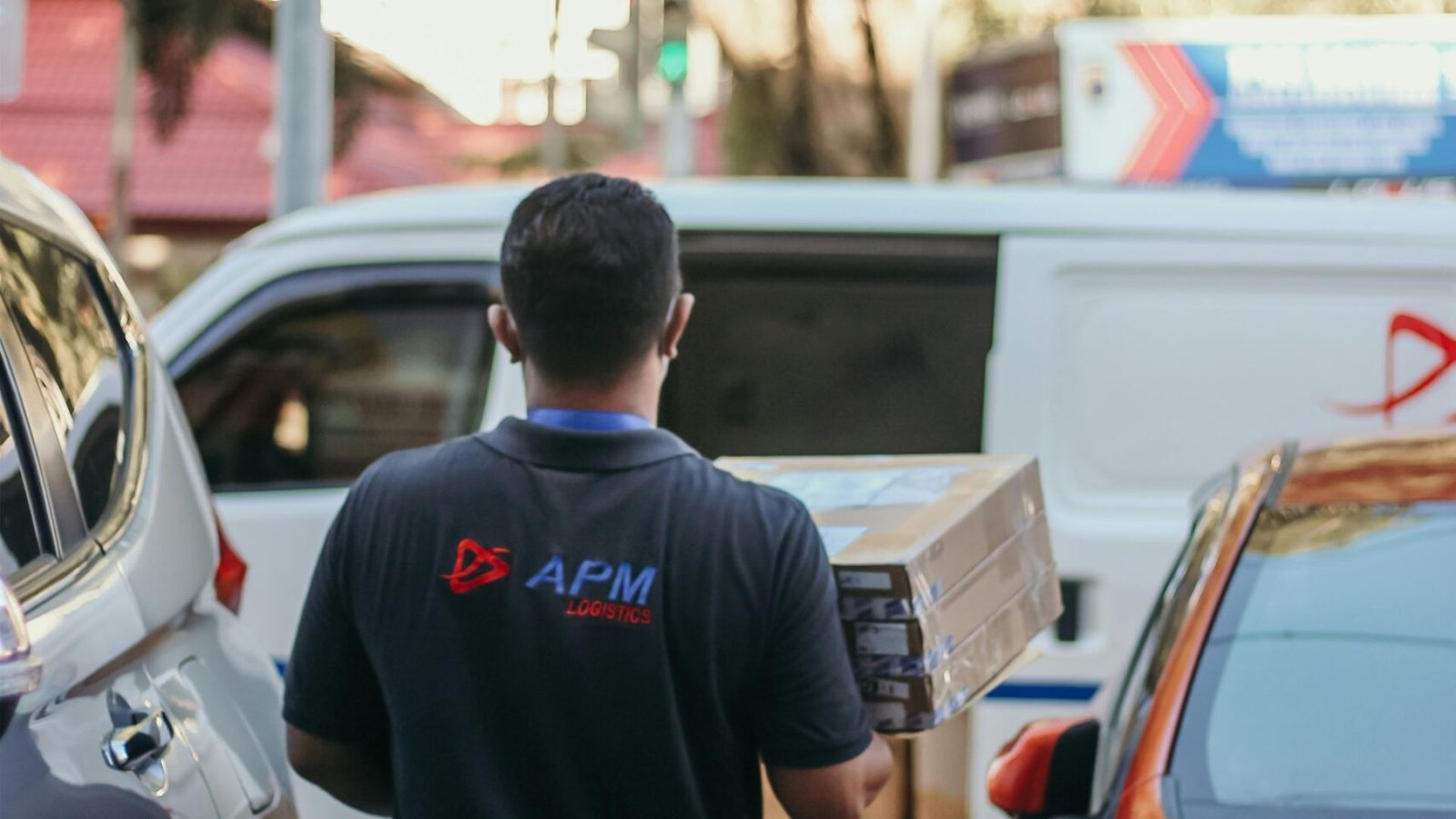 a man walking down a street next to parked cars